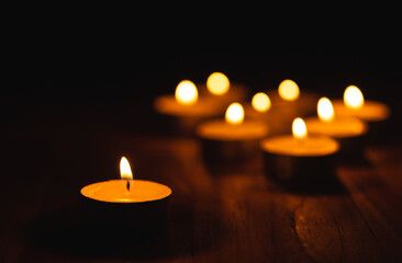 Burning Golden light of candle on black background, Mourning, grief, christmas candle light concept.