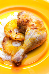 grilled chicken leg served with fried pineapple slices and rice