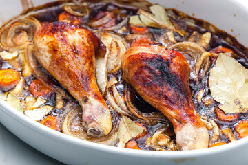 chicken legs baked with onion, carrot and bay leaves
