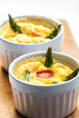 baked eggs with green asparagus, tomato and spring onion