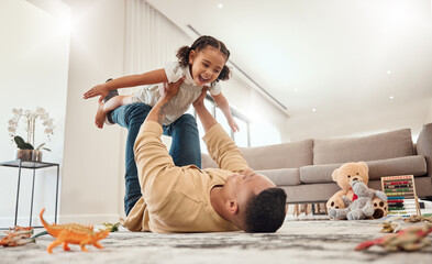 Fototapeta Happy family, father and girl playing in a house with freedom, bonding and enjoying quality time together. Happiness, smile and child flying in dads arms on the floor on a weekend at home in Portugal obraz