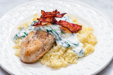 poultry breast with spinach creamy sauce and bacon served with couscous