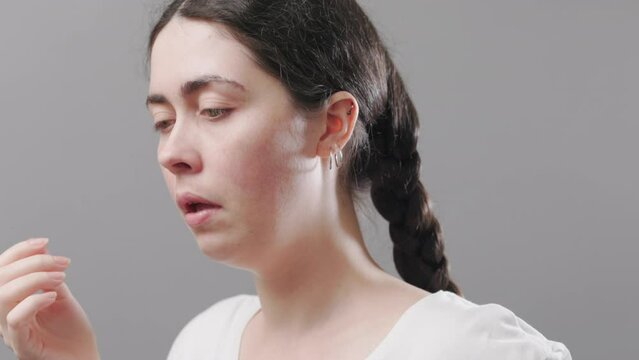 Portrait of a young caucasian woman touching her nose. Treatment of runny nose and viral infections. Concept of allergy and flu.