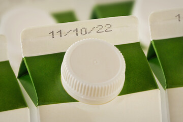 Close-up of milk cartons with expiration date
