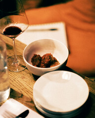 Sicilian meatballs in. a bowl with a low glass of red wine