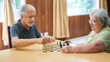Senioren Paar beim Schach spielen zu Hause