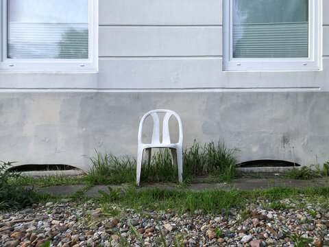 Plastikstuhl vor Hauswand