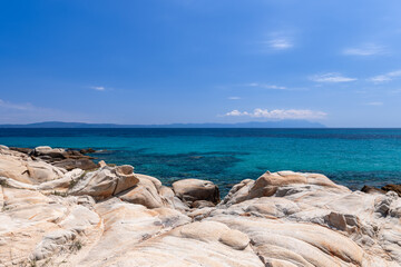Unusual rounded rocks on costal line of Karidi beach, shallow warm water like in home bath. Vourvourou bay, Sithonia, Chalkidiki, Greece