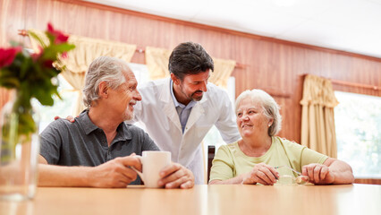 Arzt im Gespräch mit einem Paar Senioren im Altersheim