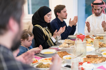 Fototapeta na wymiar Muslim family making iftar dua to break fasting during Ramadan.