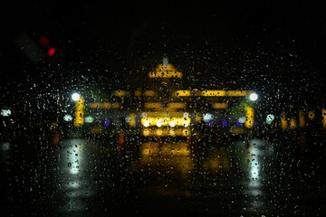 Blurry rainwater and view Gedung Sate building at night.