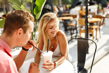 Young couple sitting in a cafe and speaking. Students during break in the cafe place.Enjoying a great first date.