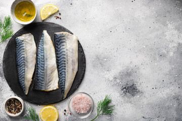 seafood background with ingredients for cooking. Raw fresh fillet mackerel fish with aromatic herbs, spices, lemon and olive oil on kitchen table. place for text - obrazy, fototapety, plakaty