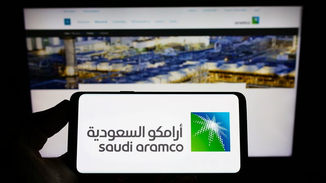 Stuttgart, Germany - 10-09-2022: Person holding smartphone with logo of oil and gas company Saudi Aramco on screen in front of website. Focus on phone display.