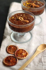 Bowl of homemade chocolate chia pudding, made with dark chocolate, chia seeds, orange juice and plant based milk. Selective focus.