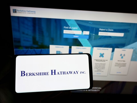 Stuttgart, Germany - 10-09-2022: Person holding smartphone with logo of US holding company Berkshire Hathaway Inc. on screen in front of website. Focus on phone display.