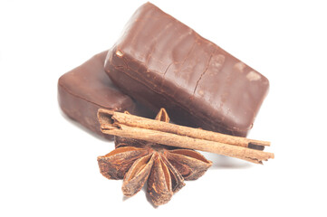 gourmet chocolate bonbons with anise and cinnamon sticks isolated on white background