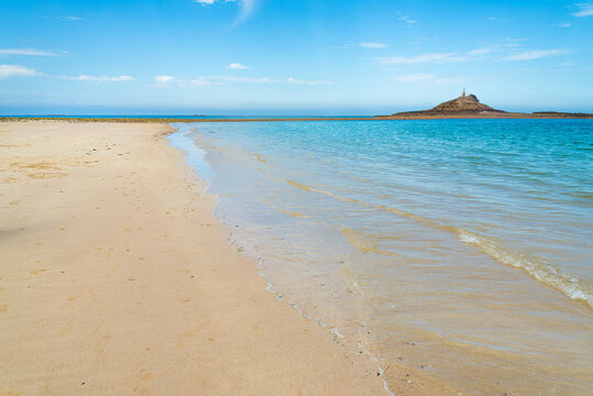The idyllic shore of the "Ilot Saint Michel" (Saint Michel Island), Brittany, France. The shore with sand and turquoise ocean waters on the foreground. With copy-space.