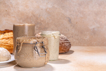 Healthy lifestyle, gluten free fermenting diet. Homemade sourdough. Active bubbly rye, wheat, oat sourdough with different flour and fermentation methods, in glass jars, with raw dough and baked bread - obrazy, fototapety, plakaty