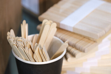 Stacked paper cups, brown paper coffee cup and wooden spoons background