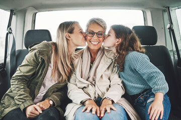 Family, kiss and road trip with a girl, mother and grandmother in the backseat of a car for a...