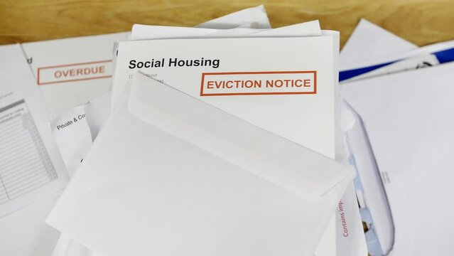 A pile of bills and letters with an eviction notice for social housing