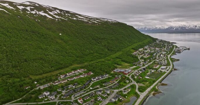 Troms&oslash; Norway Aerial v4 drone flyover along european route e8 coastal drive across hjorten, reinen, gammelg&aring;rden neighborhoods with mountainscape view - Shot with Mavic 3 Cine - June 2022