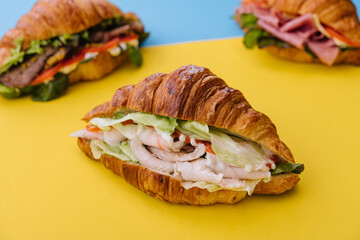 croissant sandwich ham on yellow with blue background