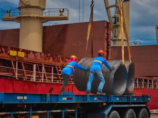 Port operation is discharging steel wire rod from vessel to truck by stevedore.