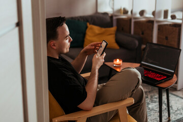 Young man using smartphone to work from home