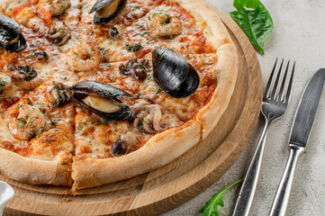 Tasty pizza with a seafood, squids and mussels on the concrete background