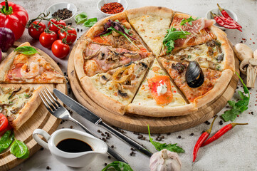Pieces of different pizza flat lay on concrete background