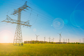 Beautiful farm landscape and industrial high voltage power line pylons and wind turbines farm at...