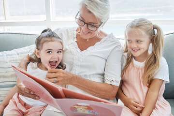 Grandmother, children and reading books on living room sofa in family home educational learning,...