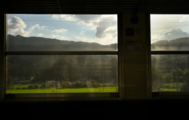鉄道の車窓から見える田園風景と山々
