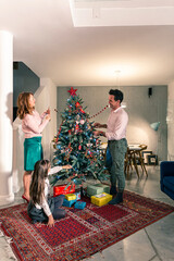 A happy family around the Christmas tree in a decorated living room