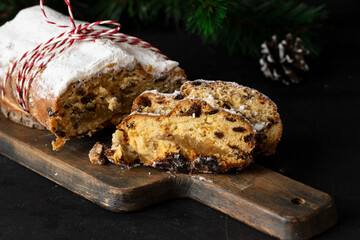 Stollen on the cut board with Christmas decoration. German fruit bread with nuts, spices, dried...