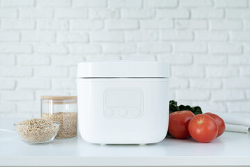 Electric rice cooker on wooden counter-top in the kitchen