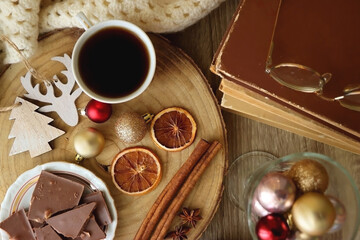 Cup of tea or coffee, various sweets and spices, Christmas decorations, comfy blanket, books and...
