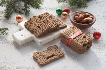 Speculoos or Spekulatius, Christmas biscuits, chocolate balls and almonds on a table with fir twigs. Traditional German sweets, cookies for Christmas or Advent, wintertime snacks.