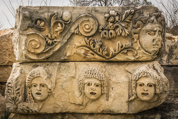 Preserved bas-reliefs with floral ornaments and faces, Demre, Antalya, Turkey. Theater masks.