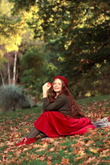 red-haired fairy-tale girl sits in the park on a plaid. High quality photo
