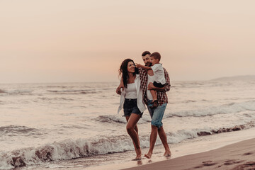 The family enjoys their vacation as they walk the sandy beach with their son. Selective focus 