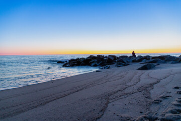 Blue hour on the beach with rocks in the water, long exposure