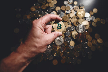 Bitcoin. Cryptocurrency Gold Bitcoin, BTC, Bit Coin. Macro shot of bitcoin coins isolated on black background with human hand. Blockchain technology, bitcoin mining concept.