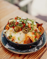 Nachos con queso, carne, guacamole y tomate
