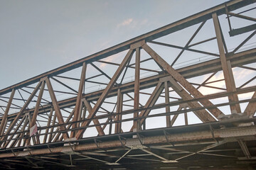 Obraz premium View of the rusty old railway bridge over the river.