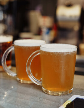 Dos jarras de cerveza fr&iacute;as en la mesa de una terraza