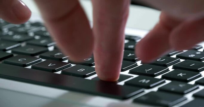 Female hands typing on laptop keyboard, closeup