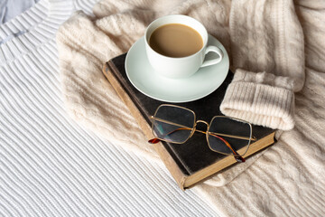 Book with mug of cocoa on white with beige background
